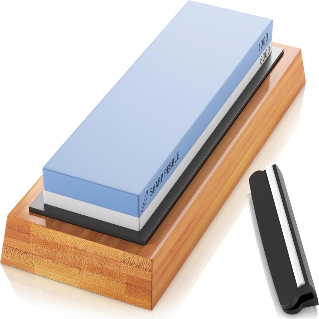 A Sharp Pebble premium whetstone sharpening kit featuring a dual-grit sharpening stone with 1000 and 6000 grit sides. The stone is mounted on a bamboo base for stability, and the kit includes an angle guide for precise sharpening. Ideal for maintaining sharp knife edges.